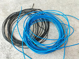 Two spools of electrical wire in blue and black.  Close-Up. 
