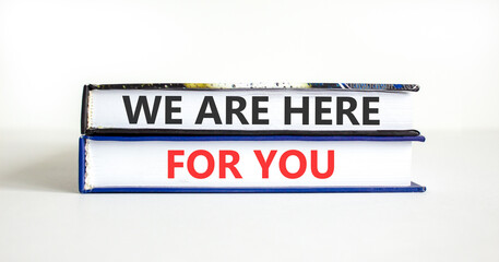 Fototapeta premium Support, help and we are here for you symbol. Concept words We are here for you on beautiful books. Beautiful white paper background. Business we are here for you concept. Copy space.