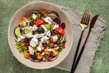 Greek salad of fresh cucumber, tomato, sweet pepper, arugula, red onion, feta cheese and olives with olive oil. Healthy food. Top view