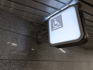 Accessible area for wheelchair users. Illuminated disabled person symbol indicates location of automatic platform for climbing steps. Assistance to people in overcoming steps on stairs