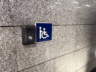Call for help button next to disabled sign and braille text for visually impaired. Comprehensive solution for people with disabilities. Creating accessible locations for wheelchair users