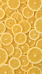 Many circular lemon slices forming a vibrant citrus pattern, perfect for summer designs, food and beverage concepts and refreshing themes.