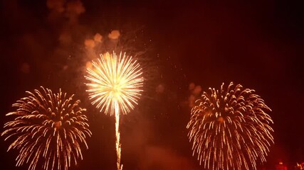 Spectacular golden fireworks illuminate the night sky, marking a festive celebration and creating a breathtaking display of light and color during an exciting event
