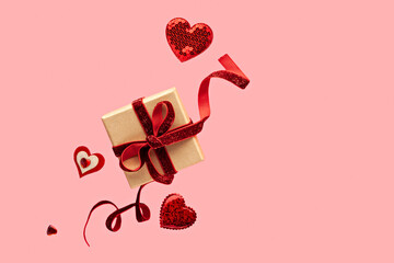 Gift Box with Red Ribbon and Hearts on Pink Background for Valentine's Day Celebration