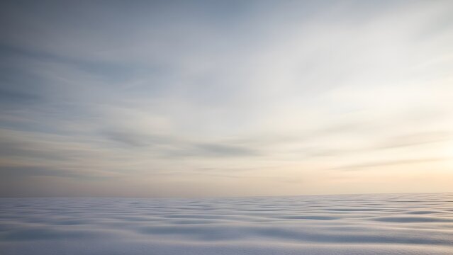 Serene ocean surface at sunset with soft ripples and cloudy sky