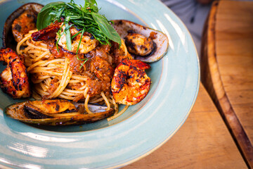 Plate of pasta with shrimp and vegetables. The dish is colorful and appetizing. The pasta is cooked and the shrimp is cooked through. The vegetables are fresh and add a nice crunch to the dish