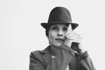 Woman hiding face with hat in studio portrait