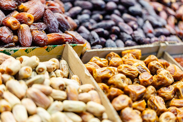 Assorted dried different types dates display at data market stall with dates, pistachios, and hazelnuts