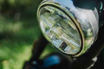 Hombre aventurero con barba en moto estilo scrambler en el bosque en dia soleado