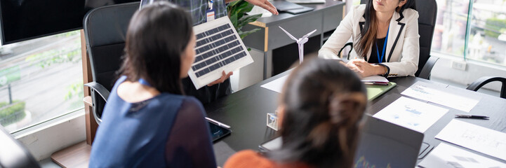 Solar panels green energy Business people working in green eco friendly office business meeting...