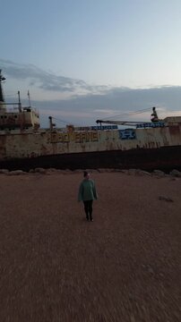 women and old rusty sheap on the background