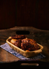 Fried chicken wings with potatoes on a rustic background. Soft focus.