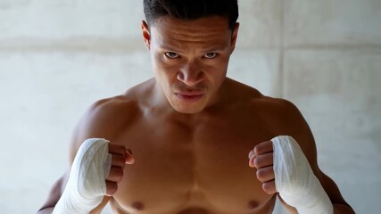 Determined boxer with wrapped hands preparing for intense training session