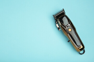 Hair clipper on light blue background. Modern hair clipper.