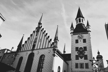 ドイツのミュンヘンにある旧市庁舎のモノクロ写真 マリエン広場に位置する白い壁と時計塔が特徴的な歴史的建造物 おもちゃ博物館としても利用されているゴシック様式の建築風景 バイエルンの伝統を感じさせるクラシックなイメージ