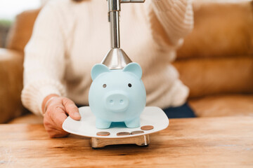 Counting coins using a scale with a blue piggy bank on a table in a living room