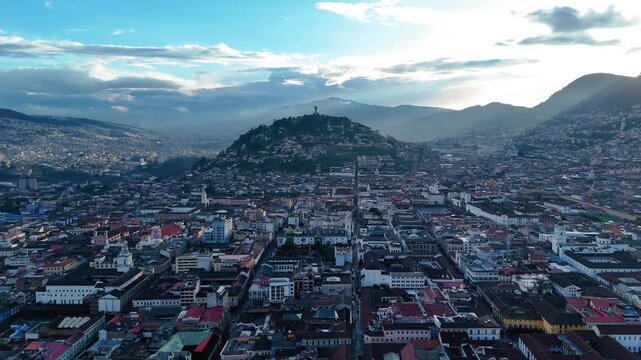 Aerial drone footage of El Panecillo hill featuring the iconic Virgin of Quito statue overlooking the city of Quito, Ecuador. Important cultural and religious landmark with panoramic views of the capi