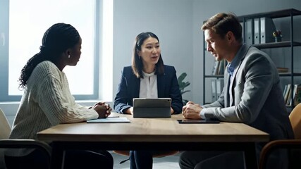 Professional diverse business team collaborating in a focused office meeting, discussing strategies and project plans around a conference table in a modern corporate setting