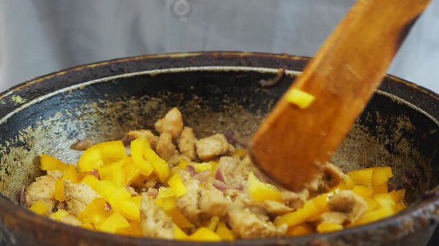 In a deep cast-iron skillet, chicken marinated in teriyaki sauce and yellow pepper