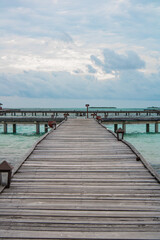 Obraz premium Langer Holzsteg führt über türkisfarbenes Meer