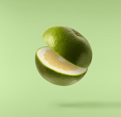 Fresh ripe green sweetie falling in the air isolated on green background