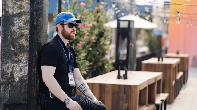 Medium shot showing a security staff member monitoring WiFi extender devices around an outdoor event space to ensure seamless internet access across the venue.