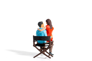 Miniature Couple Embracing While Sitting Together