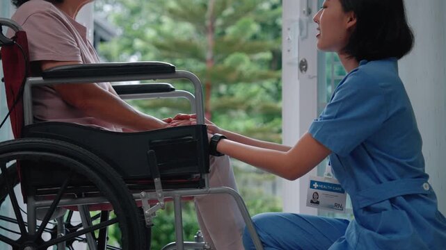 Nurse holding hands of senior patient in wheelchair, expressing empathy, trust, and emotional support in home healthcare setting.

