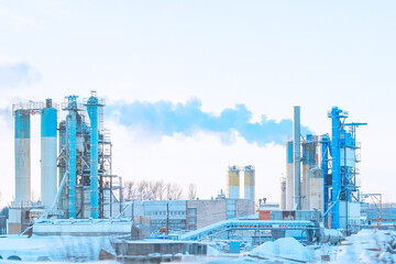 Obraz premium Russia, Saint Petersburg, 11.01.2026 Industrial factory with emission pipe releasing smoke into the sky. Manufacturing plant during winter with environmental impact concept.