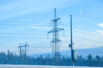 Russia, Saint Petersburg, 11.01.2026 Power lines and high voltage towers over a snowy forest landscape. Electricity transmission infrastructure in winter cold weather.