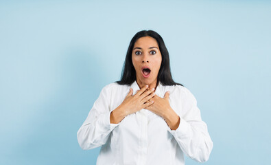 portrait of adult mexican woman surprised on blue background in Mexico Latin America, or Latina middle aged brunette shocked female