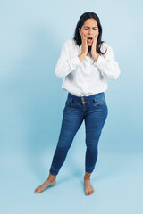 portrait of adult mexican woman with headache pain on blue background in Mexico Latin America, or Latina middle aged brunette female feeling bad
