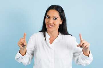 portrait of adult mexican woman smiling on blue background in Mexico Latin America, or Latina middle aged brunette female 