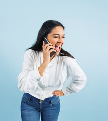 portrait of adult mexican woman talking by phone on blue background in Mexico Latin America, or Latina middle aged brunette female on a call
