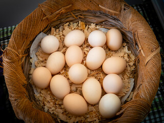 Fresh Farm Eggs in Rustic Wicker Basket, Top View Natural Food Concept. Stock photo.