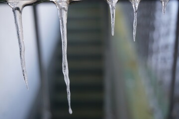 Eiszapfen vor alter Kellertreppe von Haus bei Frost, Eis und K&auml;lte am Mittag im Winter