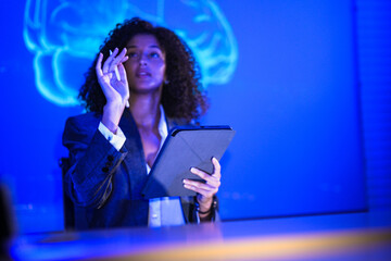 Cyber security specialist monitoring network safety on virtual display. Female IT engineer with tablet scanning digital system for hacker threats in control room.