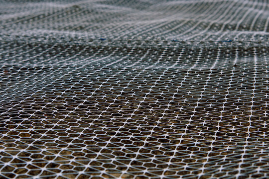 Groundwork preparation with geogrid wire mesh laid out on sub-soil surface for ground stabilisation and bearing capacity improvement
