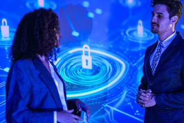 Professional IT consultants planning system defense solution. Tech experts explaining data encryption and password security to client at modern night seminar.