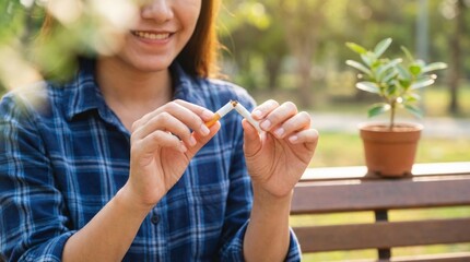 Young woman breaking cigarette outdoors,concept of quitting smoking,healthy lifestyle and anti-addiction awareness in public health