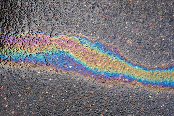 Fuel spill creating vibrant rainbow colors on a wet asphalt road surface