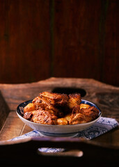 Fried chicken wings with potatoes on a rustic background. Soft focus.
