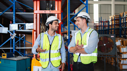 Warehouse worker in safety vest and hard hat in a large storage facility. Logistics, inventory management, and industrial supply chain concept.