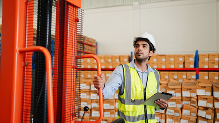 Professional warehouse workers using digital tablet with forklift and pallets. Logistics team management, inventory control, and industrial supply chain concept.