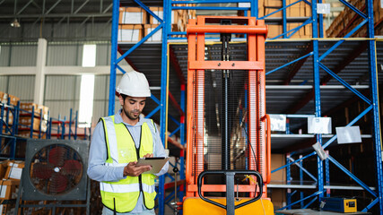 Professional warehouse workers using digital tablet with forklift and pallets. Logistics team management, inventory control, and industrial supply chain concept.