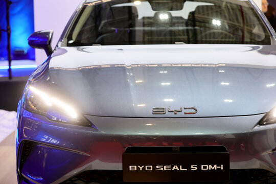 Front view with logo detail of a BYD Seal 5 DMI, plug-in hybrid, PHEV car. Automotive industry. Photographed in ambiental light. Romania, Bucharest, October 2025.
