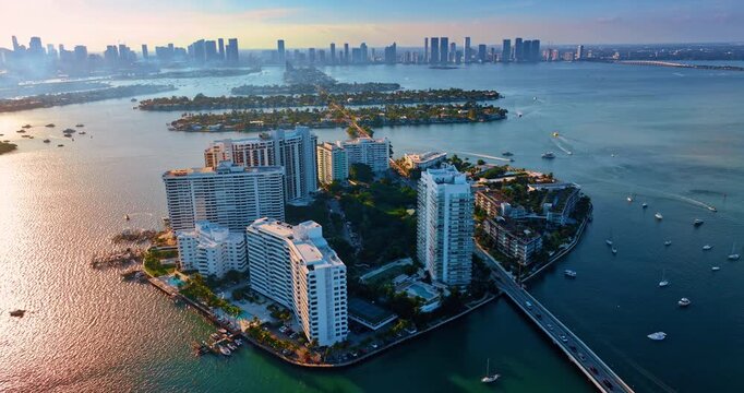Man-made islands in the Biscayne Bay with developed urban infrastructure. Aerial perspective on the Brickell Key in Miami, Florida, USA at sunset time.