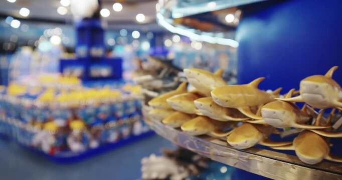 Souvenir Shop With Cute Figurines Of Sting Rays And Sharks. Buying Souvenirs From Your Travels. Souvenirs As Keepsakes. Small Yellow Shark Figurines. Travel Gifts