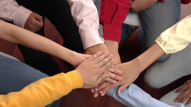 Panoramic video happy asian startup company employee wearing colorful casual cloth sit around together stack hand together symbol good teamwork, harmony team, positive environment workplace. Synergic