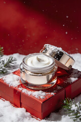 Luxury Face Cream on Red Gift Box with Snow, Winter Skincare Concept
